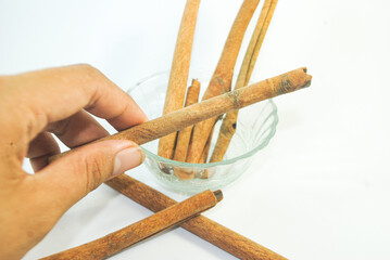 hand holding cinnamon on a white background 
