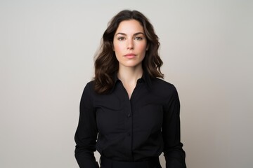 Portrait of a beautiful business woman in black shirt on grey background