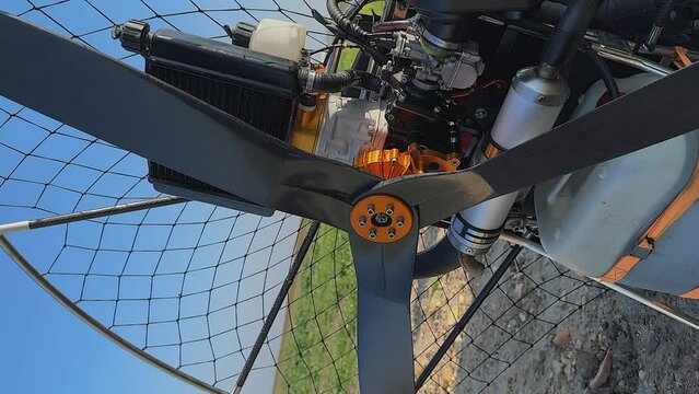 Vertical format: Closeup detail view of paramotor engine and propeller