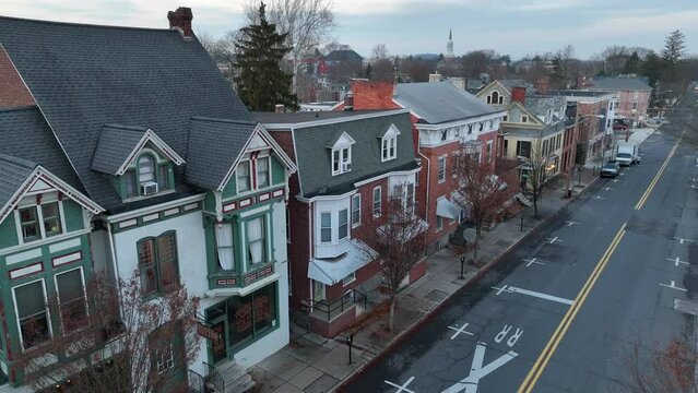 Aerial establishing shot of old suburban homes in winter. Picturesque American street scene.