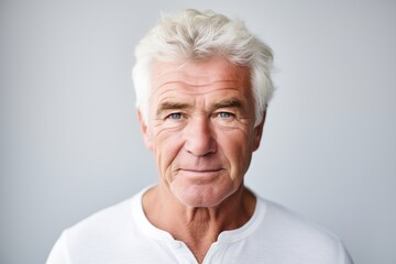 Portrait of a senior man with grey hair, isolated on grey background