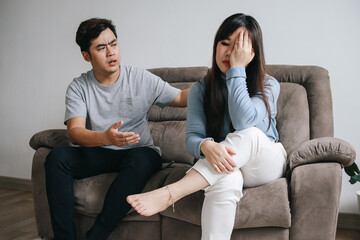 Young Asian couple having quarrel and arguing at home. Negative emotions and family problems concept - obrazy, fototapety, plakaty