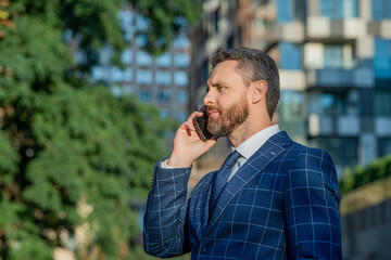 businessman has smartphone call outdoor, copy space. businessman having smartphone call