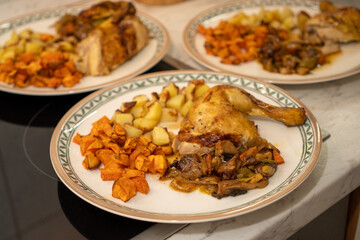 Three plates topped with grilled chicken, sweet potato and potato cubes and mixed vegetables. Close-up with selected focus