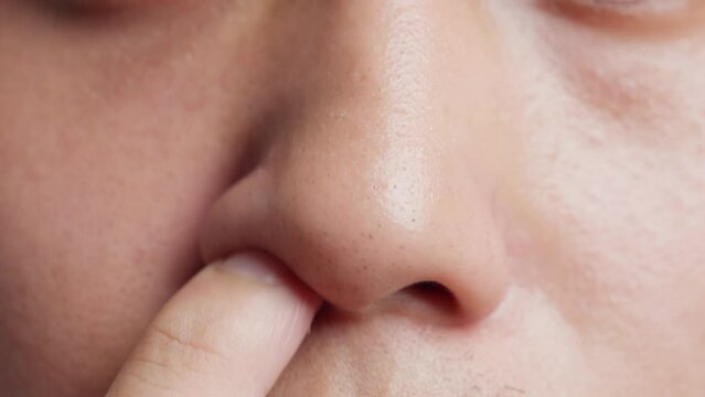 Close up of a young man picking nose with finger. Filthy habit.