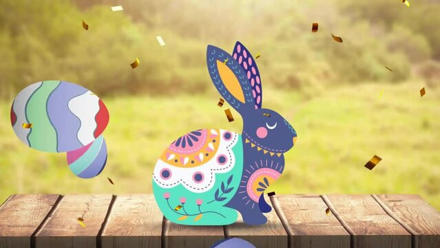 Animation of confetti over colourful rabbit with easter eggs on wooden table at easter