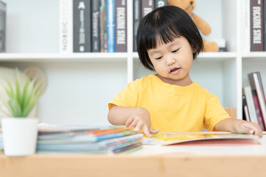 Happy Asian children relax read book at home. daughter and reading a story. learn development, childcare, laughing, education, storytelling, practice, imagine, reduce addiction mobile phone.