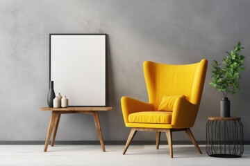  a yellow chair next to a table with a potted plant and a picture frame hanging on a gray wall.