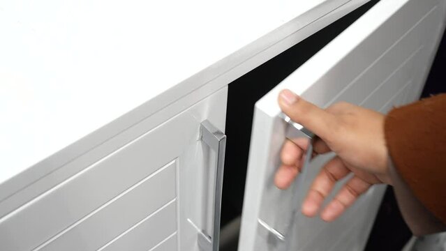  women hand open drawer wooden in cabinet