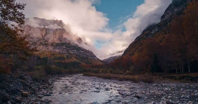 Ordesa national park valley mountains and river on a cloudy and misty winter afternoon timelapse of clouds rolling over mountain peaks in fall autumn season