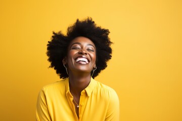 Fototapeta na wymiar Portrait of beautiful young african american woman with afro hairstyle on yellow background