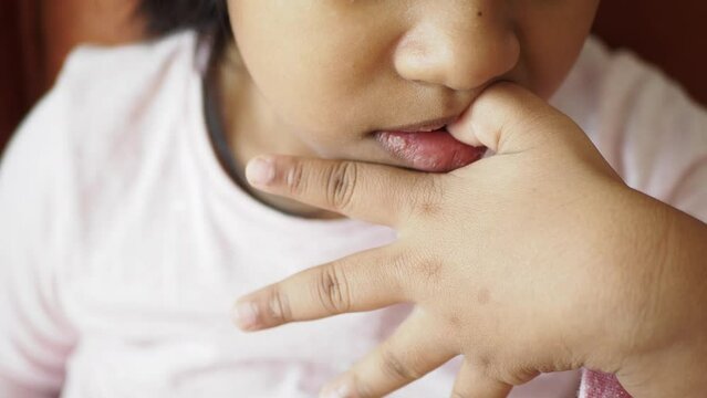  child girl biting her nails at home,