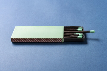 angle view green matchbox on a blue background at horizontal composition