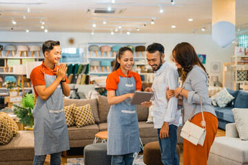 shop assistants serve shoppers with a digital tablet at a furniture store