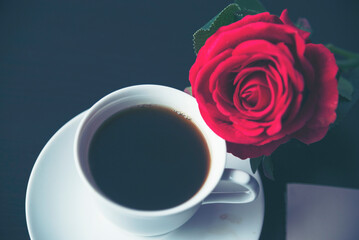 Tabletop black coffee cup red rose on wood table background with empty copy space. Espresso shot caffeine hot coffee cup in cafe. Top view Black caffeine dark beverage in cafeteria with copy space