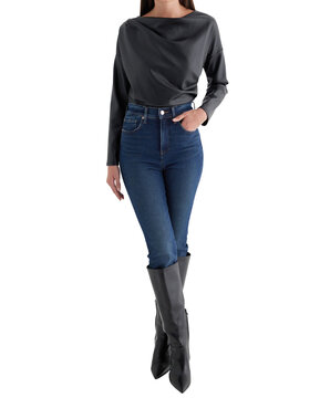 In the above picture a beautiful model is standing wearing black boots jeans pants and black dress.