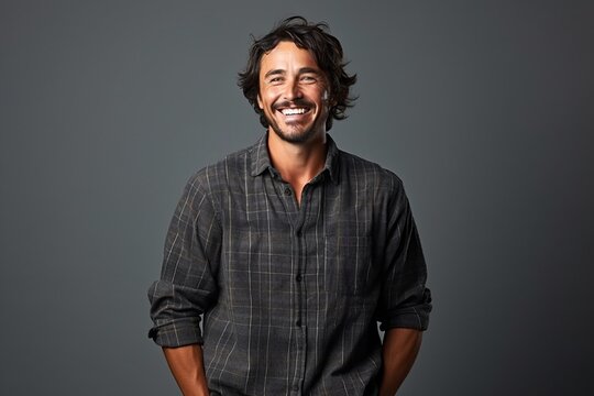 young handsome hipster man posing in studio, smiling and looking at camera