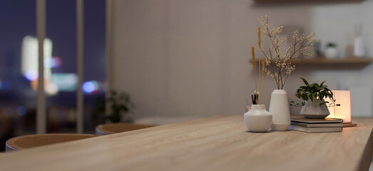 A copy space on a wooden dining table with decor in a cosy Scandinavian home dining room.