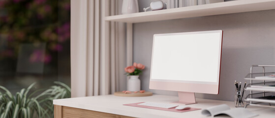 Beautiful feminine home office workspace in pink with a modern pink computer mockup on the table.