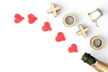 Valentine's day decoration with an open sparkling wine bottle, heart shaped candy and xoxo golden sign on white background with copy space - Powered by Adobe