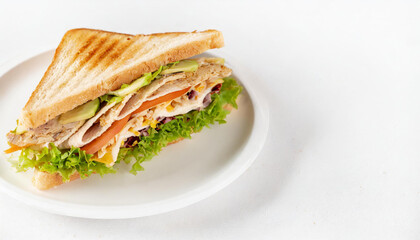 A perfect club sandwich served on a white plate and isolated against a clean white backgroun