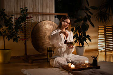 Caucasian woman in kimono performing a traditional Chinese tea ceremony using a Tibetan singing bowl