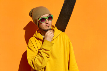 Stylish guy in a yellow hoodie posing for the camera against the