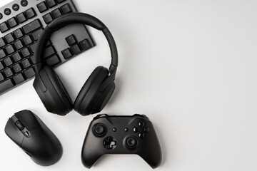 Top view of gamer table with computer keyboard, joystick and headphones