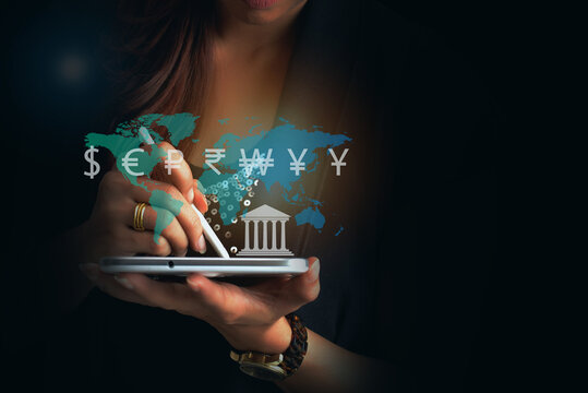 Global businesswomen and Global currency concept, money, finance, Businessman holding tablet with virtual world map and dollar yuan yen euro ruble rupees and pound sterling sign. 