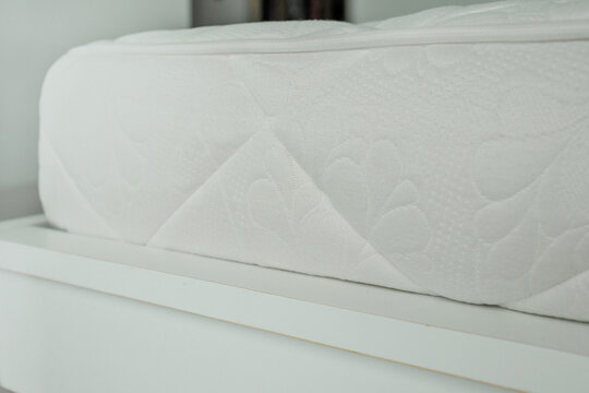 Modern bedroom in cozy appartment. White mattress close up image. Housekeeping concept