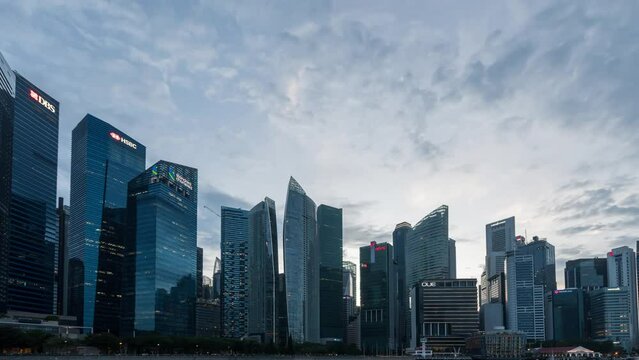 Timelapse Day to Night of Singapore City Skyline and Financial district across Marina Bay under a beautiful sky and light in Singapore. Time lapse Day to Night City.