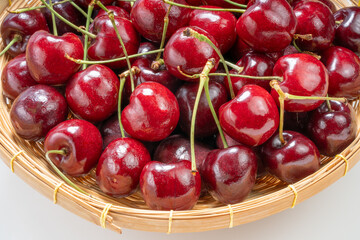 Close up shot Red Cherry in basket on wooden background.