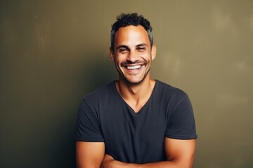 Portrait of a handsome latin man smiling at the camera against a green background