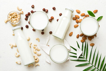 Fototapeta na wymiar Set or collection of various vegan milk almond, coconut, cashew, on table background. Vegan plant based milk and ingredients, top view