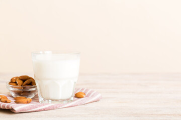 Top view of the almond milk in the glass bottle with almond nuts on the colored table. top view vith copy space