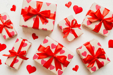 Top view photo of valentine day decorations gift box with red ribbon bow on colored background. Holiday gift boxes with top view