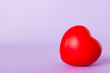 gift box with red bow and red heart on colored background. Perspective view. Flat lay