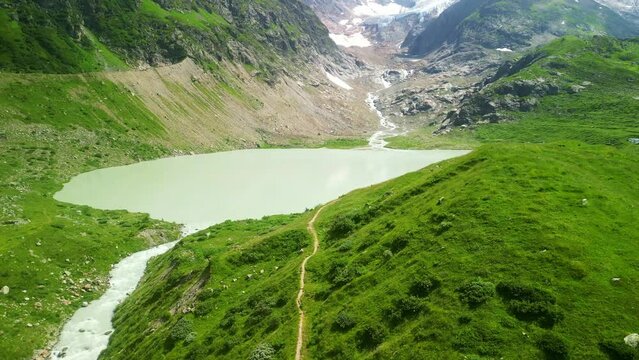 Aerial drone view of Steinsee lake mountain lake on top of Sustenpass in Switzerland. Swiss Alps road trip road summer tourism destination.