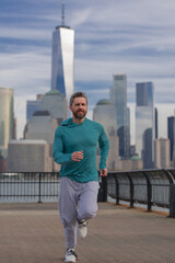 Man runner in sport outfit run in NYC. Motion, healthy run. Jogger run near Manhattan downtown. Muscular athlete sportsman run in city. Running sportswear. Handsome guy running workout outdoor.