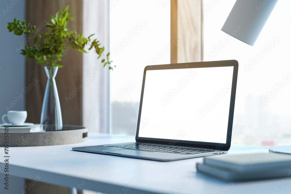 Poster Modern designer desktop with white mock up laptop, various objects and window with city view in the background. 3D Rendering.