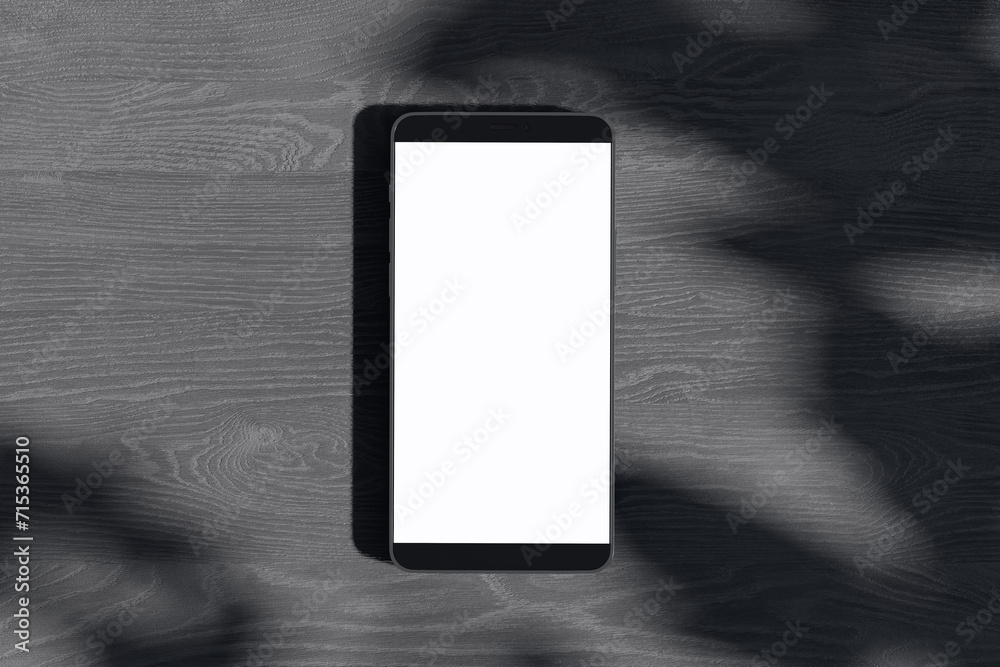 Poster Close up of empty white smartphone on dark wooden surface with leaf shadows. Presentation concept. Mock up, 3D Rendering.
