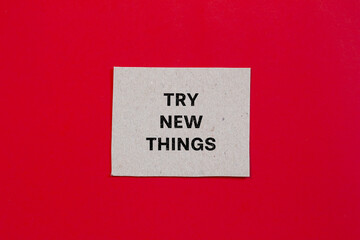 Try new things lettering on paper piece with red background. Conceptual business photo. Top view, copy space.