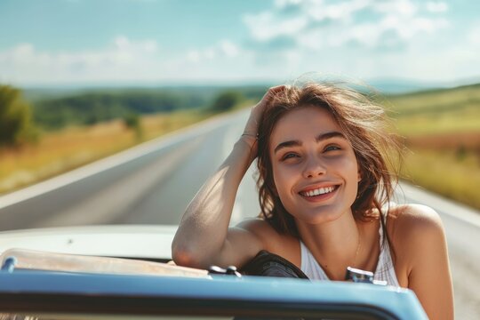 Smiling Young Woman Day Dreaming While Leaning On Convertible Car During Road Trip