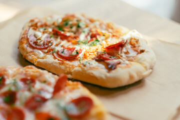 Small cute delicious pepperoni pizza served on craft paper. Selective focus.