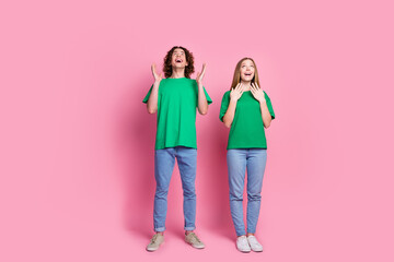 Fototapeta premium Full length photo of brunet guy and girl shocked look above head billboard casual clothing on sale isolated over pink color background