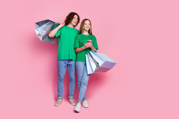 Full length body photo of youth teenagers order more gifts hold packages using smartphone free...