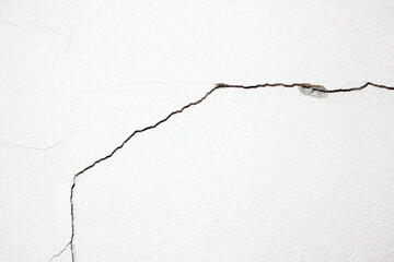 The white cement wall has cracks.