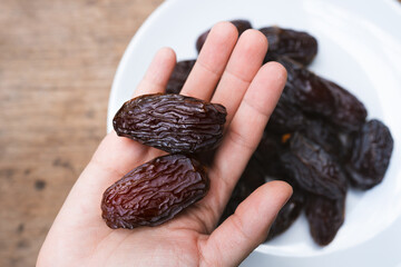 Dried Medjool dates held in the hands of a woman are a fruit rich in nutrients.