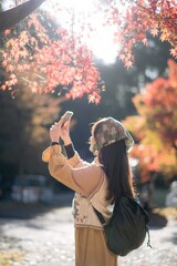 Asian woman in Kyoto's fall, wearing a casual dress, enjoys nature's beauty, capturing cheerful...