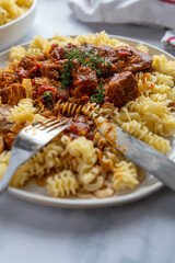 Pasta with meat and spicy sauce on a plate
